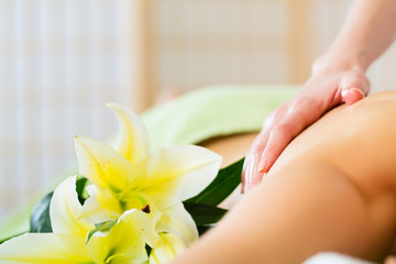 woman having wellness back massage in spa