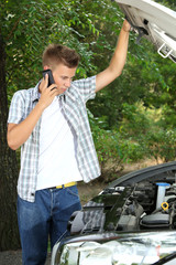 Man calling repair service after car breakdown