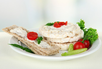 Fototapeta na wymiar Tasty crispbreads with vegetables on white table