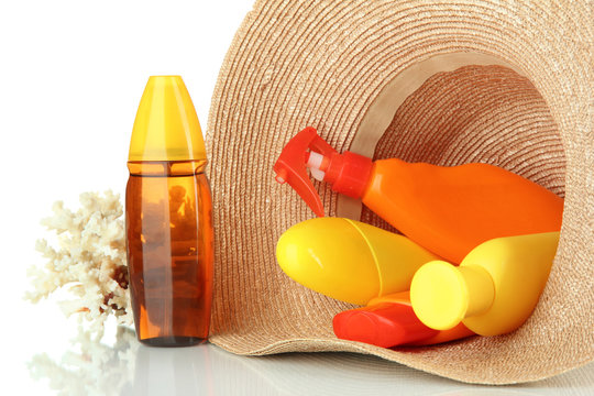 Bottles with suntan cream in hat isolated on white