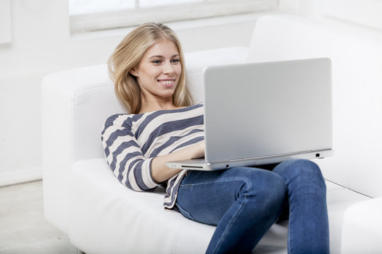 woman laying on the couch with laptop