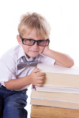 Boy in glasses with pile of books