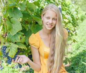 Beautiful blonde girl in fall vineyard