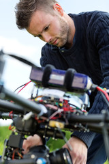 Fototapeta na wymiar Technician Fixing Camera On UAV Drone
