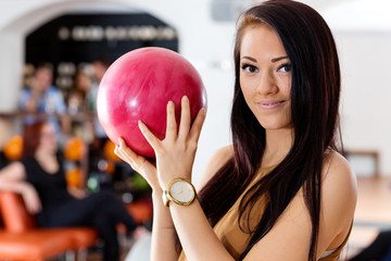 Young Woman Holding Pink Ball in Bowling Club