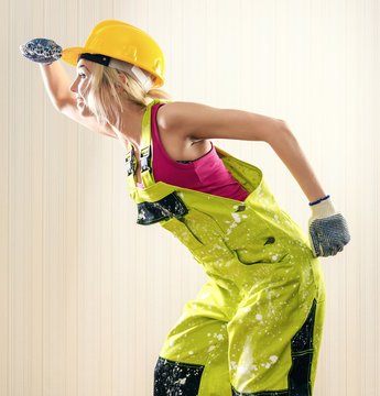Woman wearing coverall and hard hat posing indoors