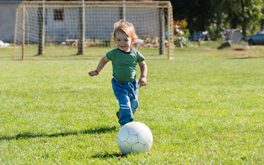 little boy running with ball