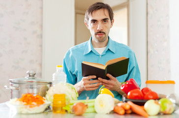 Portrait of man reading cookbook