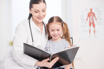 Doctor and little patient. Cheerful young doctor and little girl