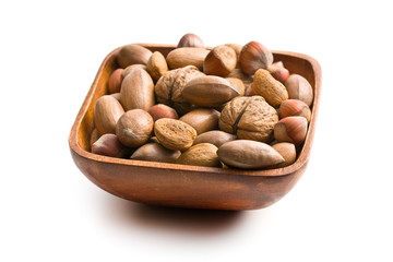 various unpeeled nuts in wooden bowl