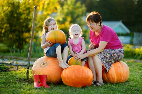 Two little sisters sitting on a huge pumpkins