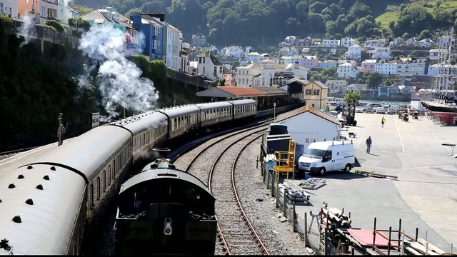 Steam Train approaching letting off steam in the station