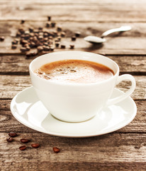 Coffee cup and beans on vintage wood table