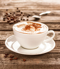 Coffee cup and beans on vintage wood table