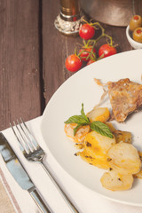 Lamb and roasted potatoes on wooden table