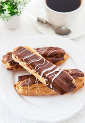 Chocolate eclairs on white plate