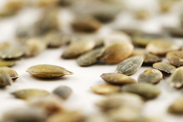 Organic green pumpkin seeds against a white background