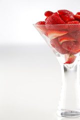 A bowl of organic fresh strawberries on a white background