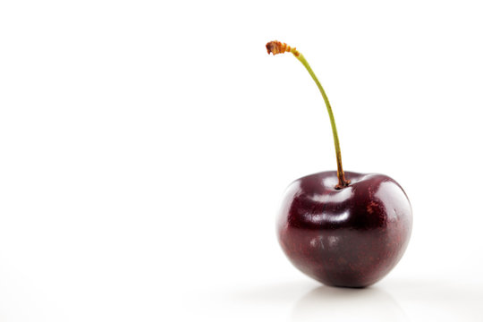 A bowl of an organic fresh cherries on a white background