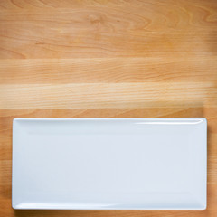 Empty white plate on wooden table