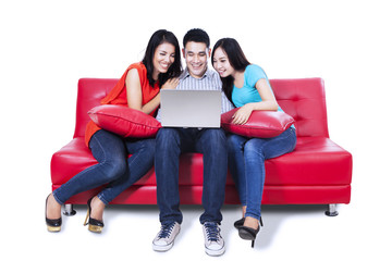 Group of friends sitting in sofa with laptop