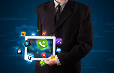 Businessman holding a tablet with modern colorful apps and icons
