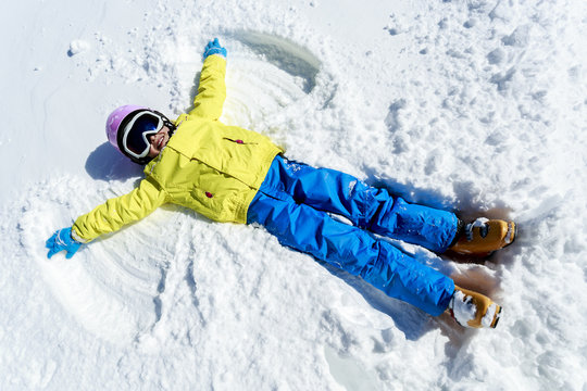 Winter fun - Snow Angel - young girl playing in snow