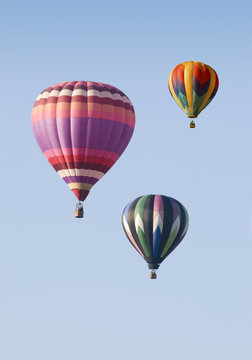 Three Hot-Air Balloons Floating against a Blue Sky