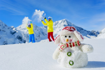 Ski,  sun and winter fun - skiers and snowman