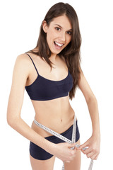 Fototapeta premium young woman measuring her waist and being happy