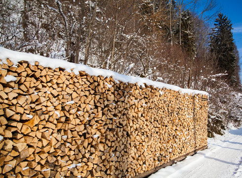 Firewood stacked in winter.  Wood pile with snow stacked for fir