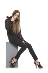 Fototapeta premium beautiful young woman in black dress, sitting wooden cube
