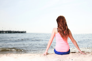 Fototapeta na wymiar Beach holidays woman enjoying summer sun sitting sand looking ha