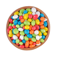 Candy sea pebbles in a wooden bowl on a white background