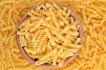 Italian pasta fusilli in a wooden bowl