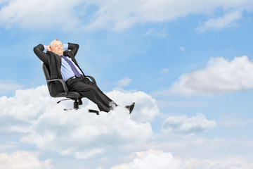 Mature businessman resting in armchair and floating on a cloud