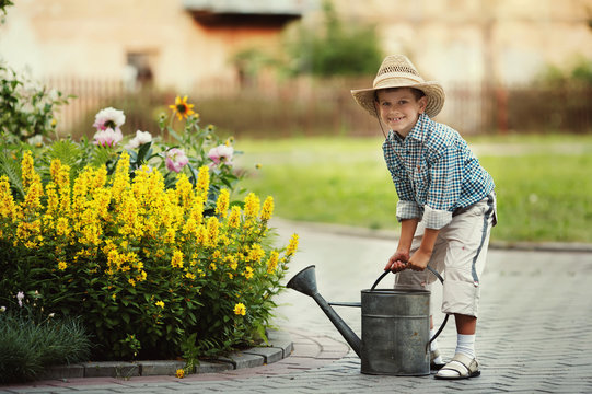 cute little boy watering flowers watering can
