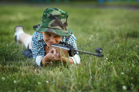 little boy with airgun outdoors