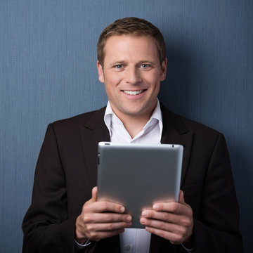 lächelnder mann hält tablet-pc in der hand