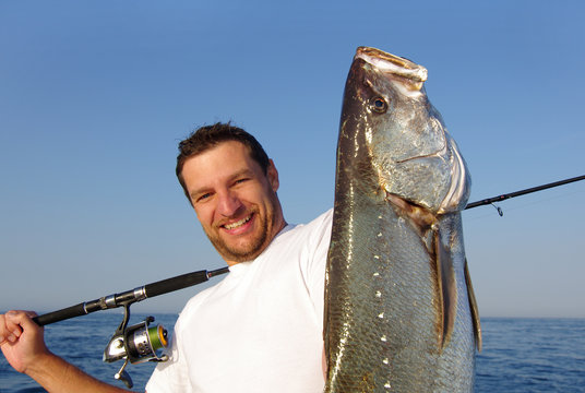 P&ecirc;cheur en mer tenant un  gros maigre (courbine)