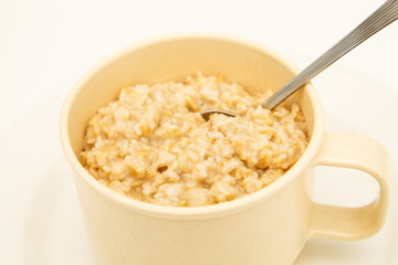 Fresh Hot Oatmeal in a Mug with Spoon