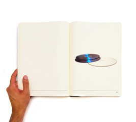 two CDs printed on white book.