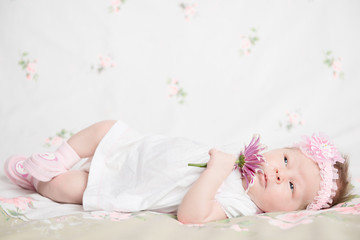 Beautiful newborn girl holding a flower