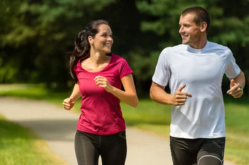 Tuinposter Cheerful Caucasian couple running outdoors © CandyBox Images