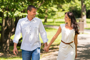 Couple walking and laughing in a park