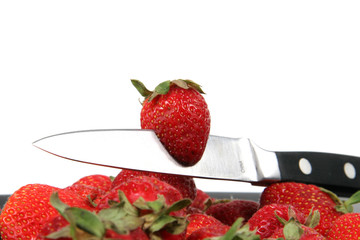 strawberries with knife over White