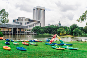 Boat on bank of river at morning on grass with building backgrou