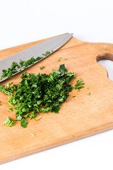 Chopped fresh herbs, wooden board and knife