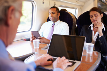 Businessman Commuting To Work On Train And Using Laptop - obrazy, fototapety, plakaty