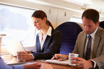 Businesswoman Commuting To Work On Train And Using Laptop